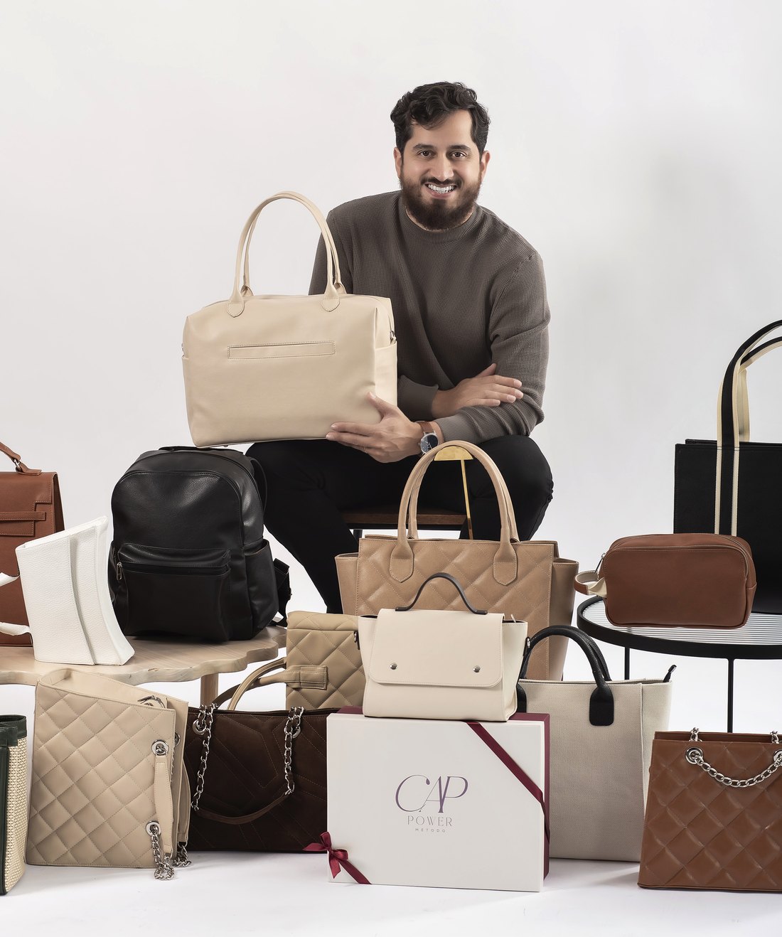 Professor Bruno, da Comunidade Artesã Power, cercado de bolsas